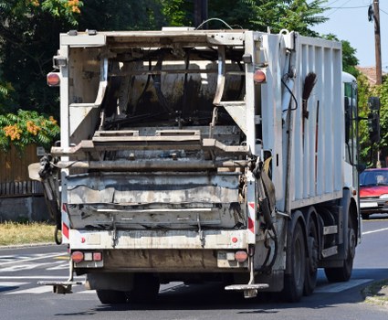 Builder's skip and crew removing construction debris in an urban basement project
